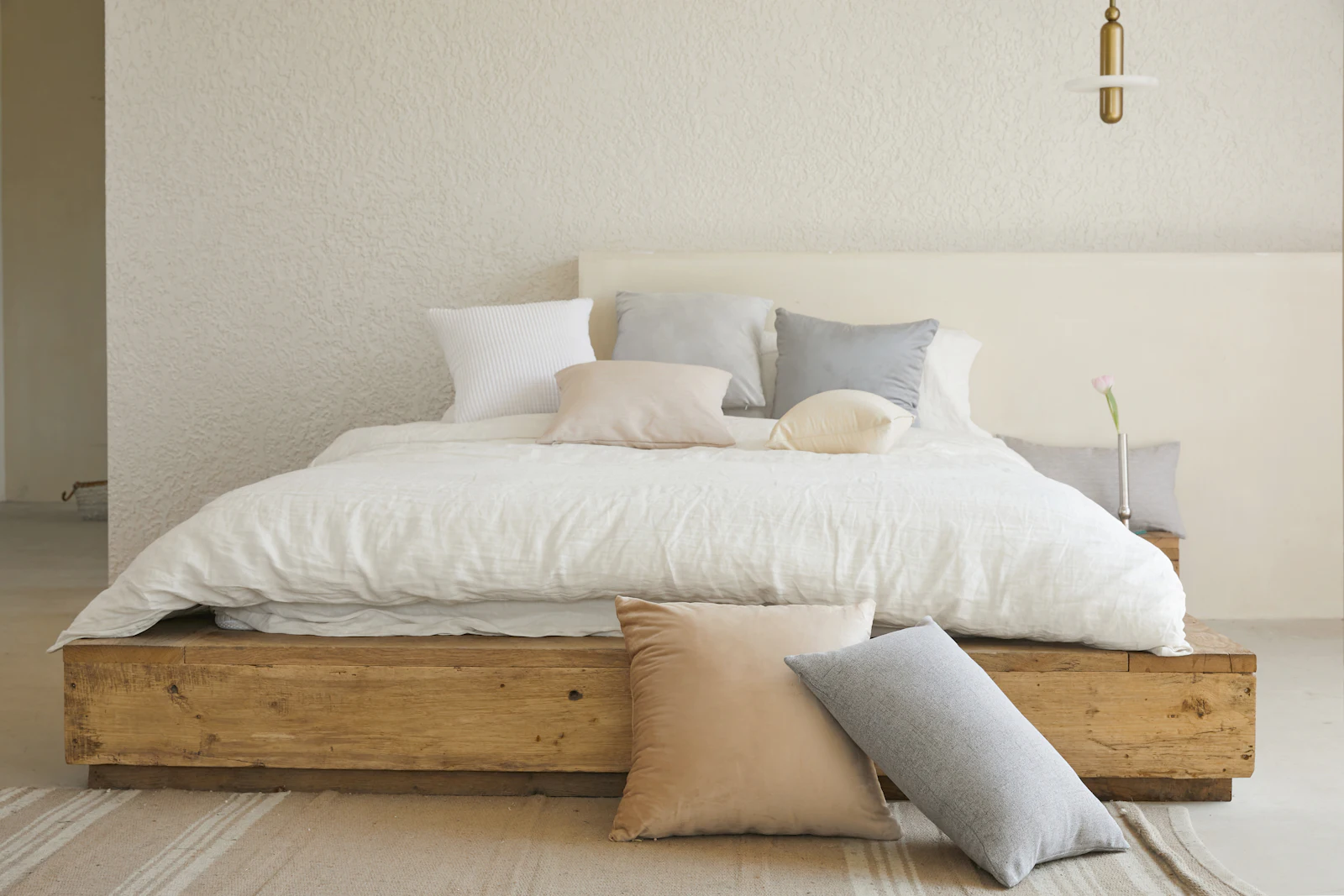 Minimal bedroom with wooden platform bed and soft white linen