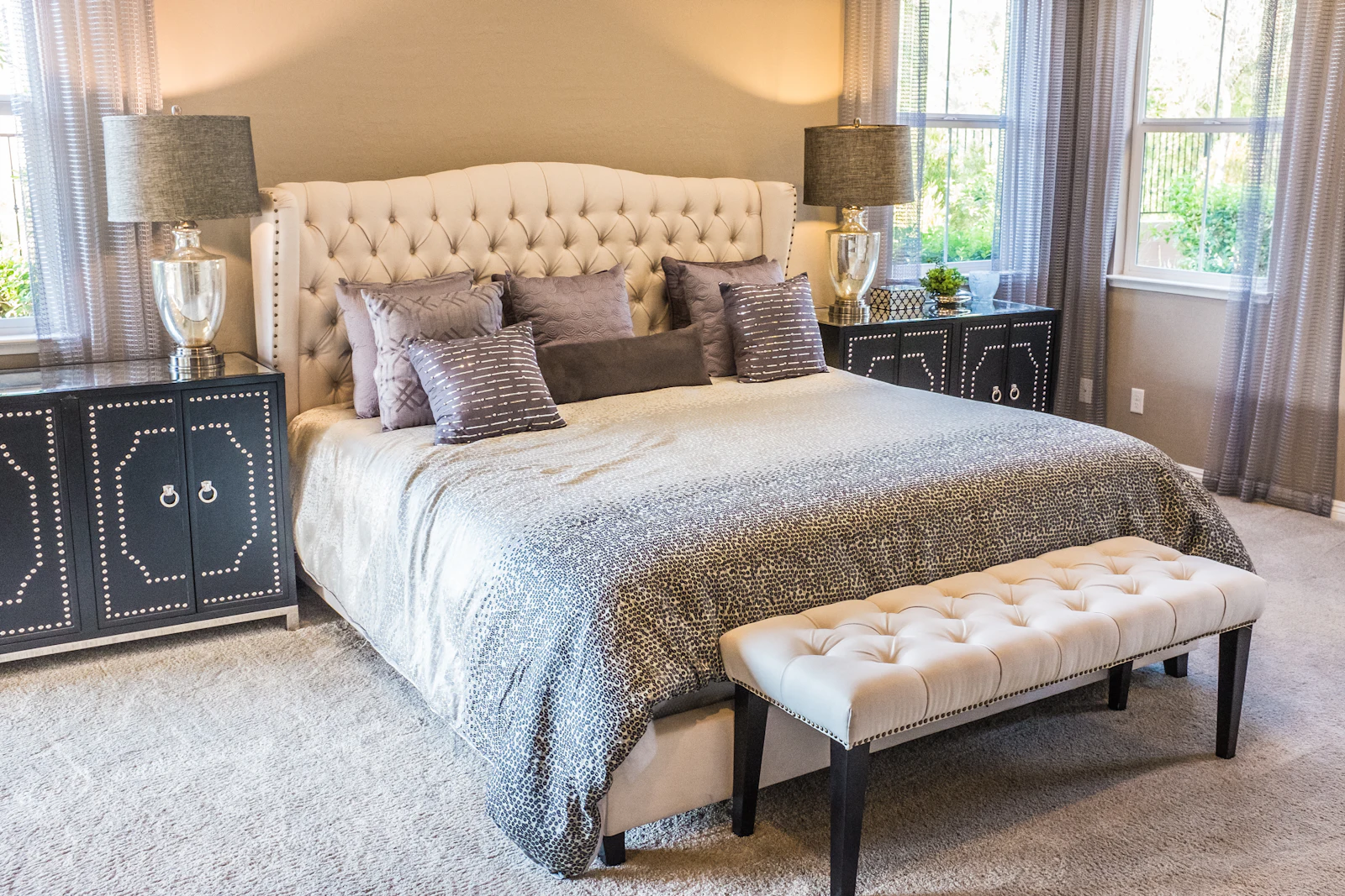 Classic bedroom with tufted headboard, bench and bedside lamps