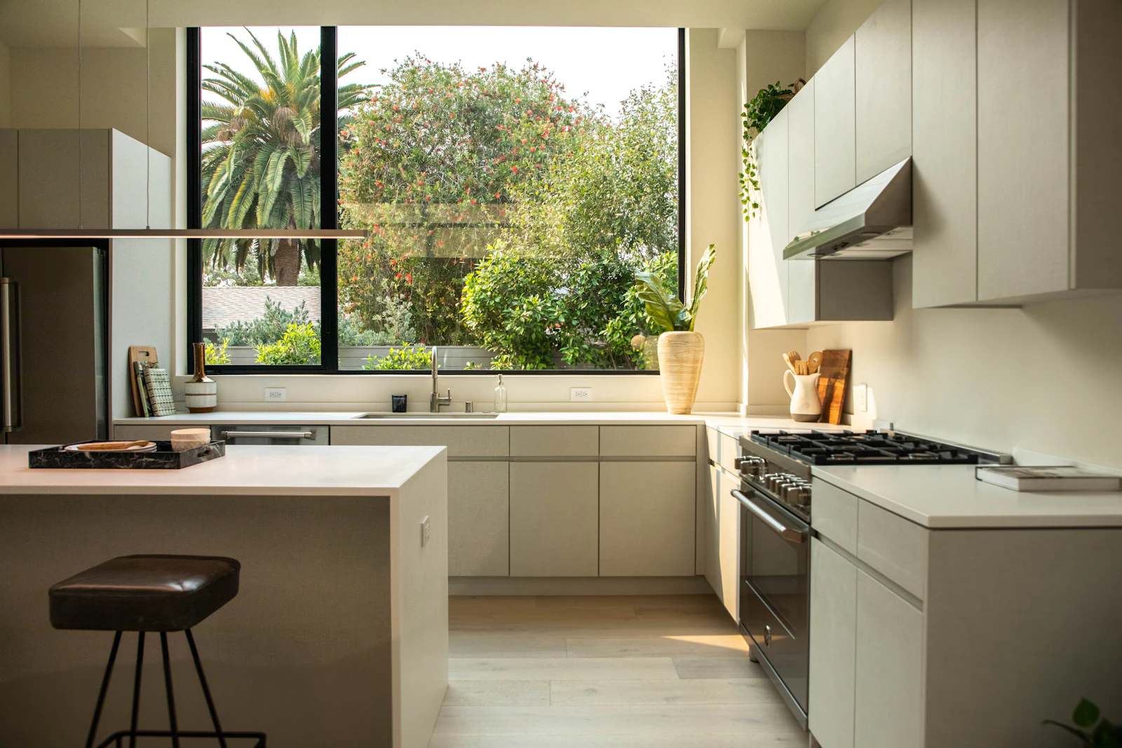 Sage-green modular kitchen with garden window and breakfast counter